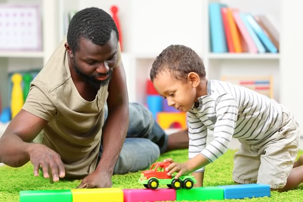 father and son with autism playing with a toy truck